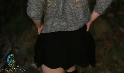 A girl in nature lifts up her black skirt and flashes her tight ass in red panties