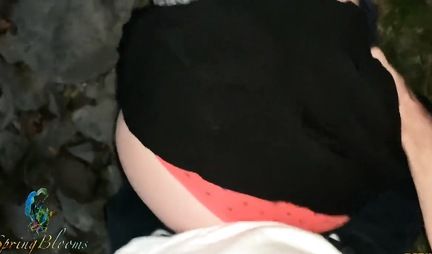 A girl in nature lifts up her black skirt and flashes her tight ass in red panties