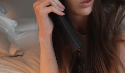 A young chick chats on the phone with a guy and fucks with another