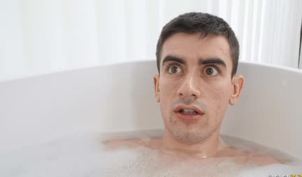 Busty MILF gives a footjob to a young male cock in the bathroom