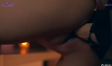 A passionate lesbian sucks a strap-on and rides it with a wet pussy